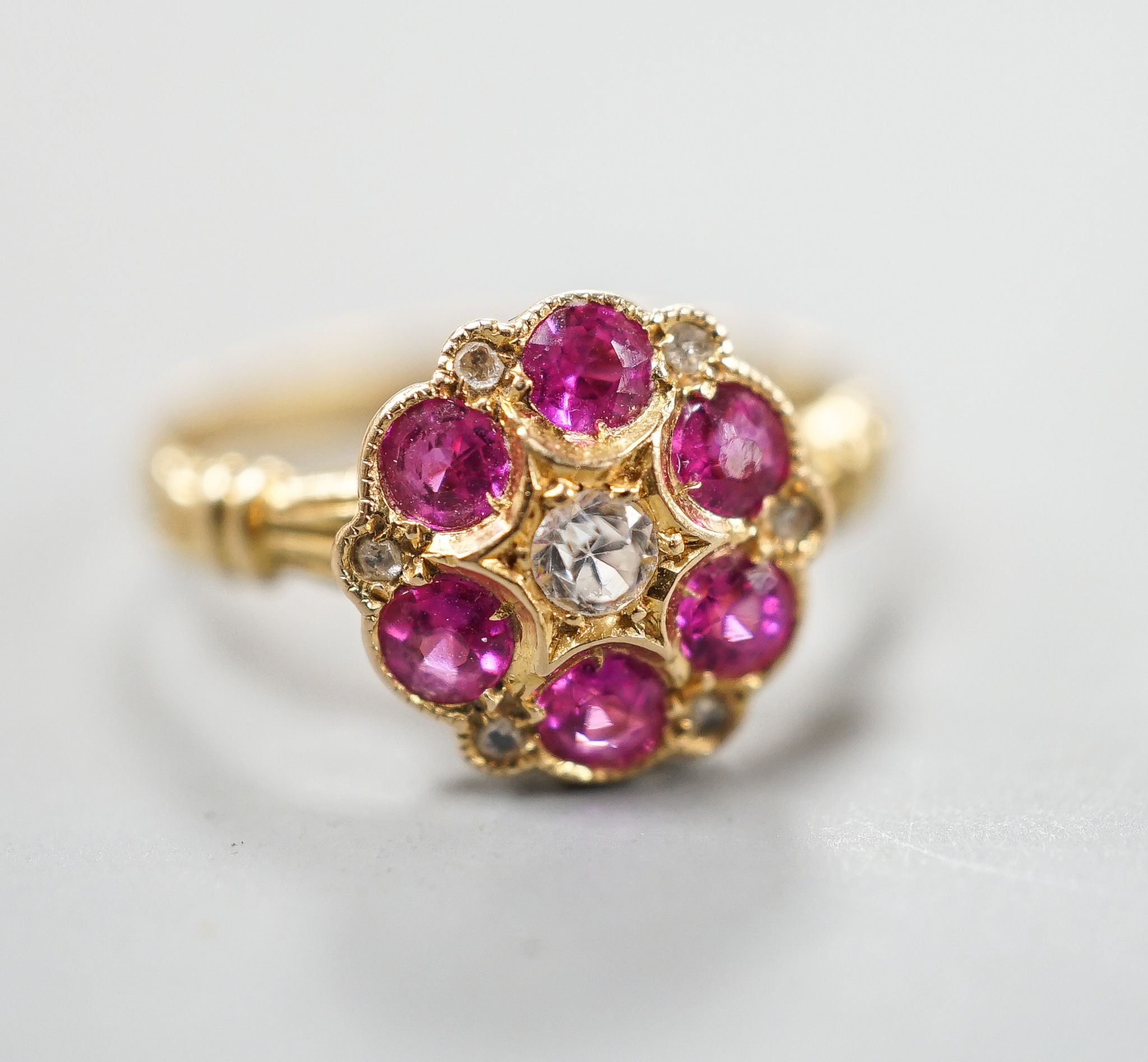 A George V 18ct gold, synthetic ruby, white sapphire? and diamond chip set cluster ring, size K, gross weight 2.4 grams.